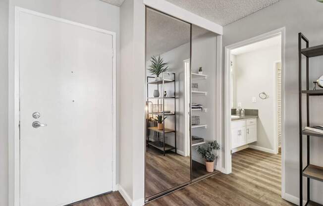 A white door is open to a kitchen and living room.