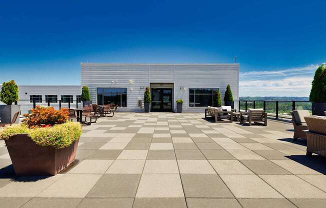 A modern building with a white exterior and a large planter in front.