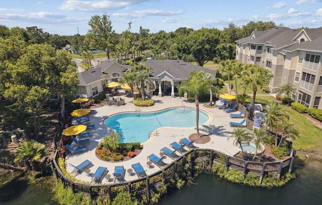 An aerial view of a resort with a pool and loungers.