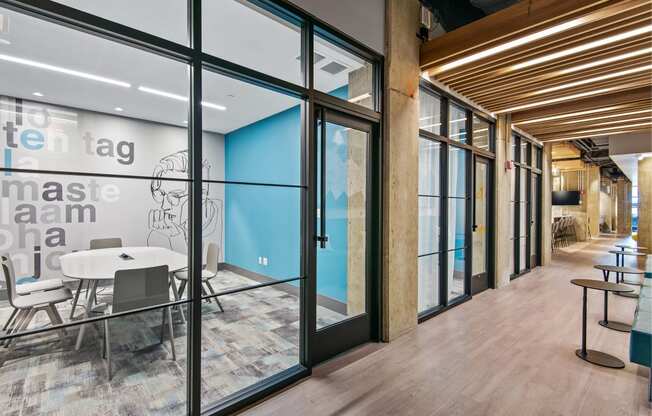 a conference room with glass doors and a table and chairs