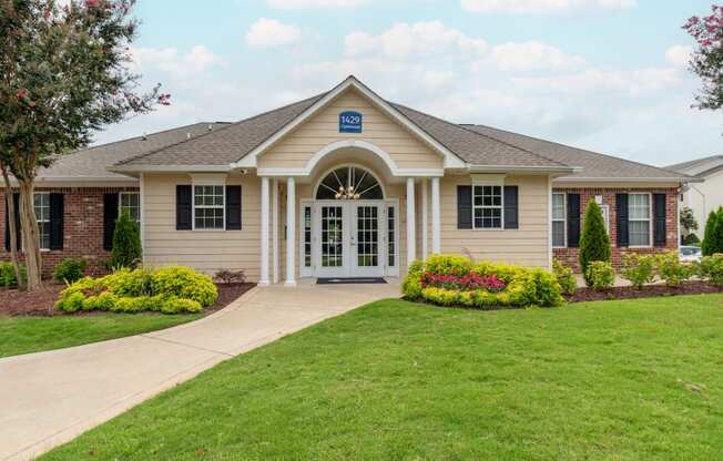 a house with a lawn and a sidewalk in front of it