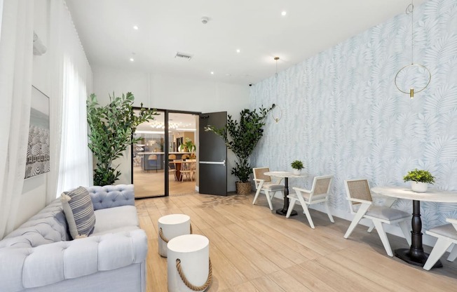 Clubhouse space with 2-person tables and a couch at Westgate on University in Lauderhill, FL