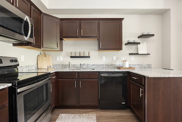 a kitchen with dark cabinets and granite counter tops