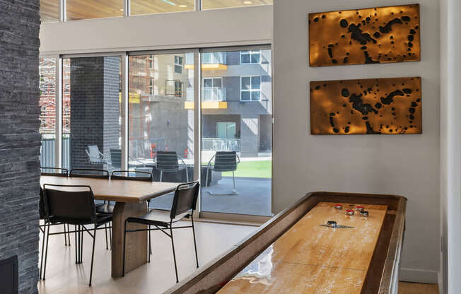 a long wooden table in a room with a large window