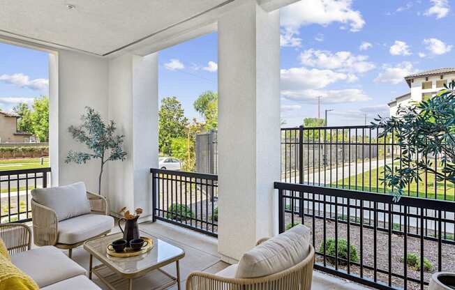 a living room with two couches and a table on a balcony