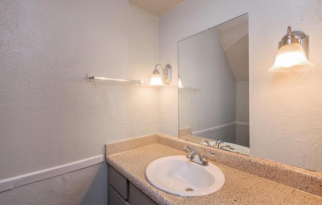 a white sink sitting under a mirror