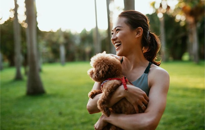 a woman holding a teddy bear in a park
