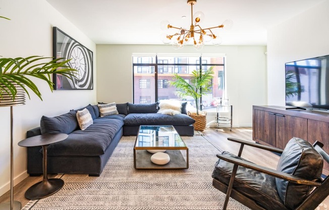 a living room with a blue couch and a large window