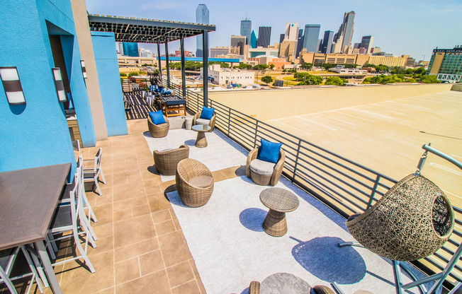 a rooftop patio with tables and chairs and a view of the city at South Side Flats, Dallas, TX