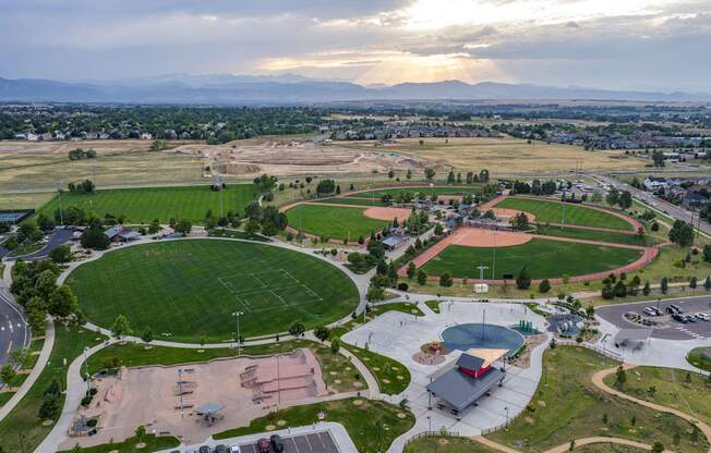 An aerial view of a sports complex with a large oval track and a basketball court.