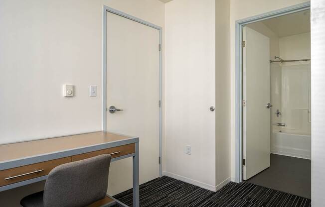 A room with a desk and chair in it.