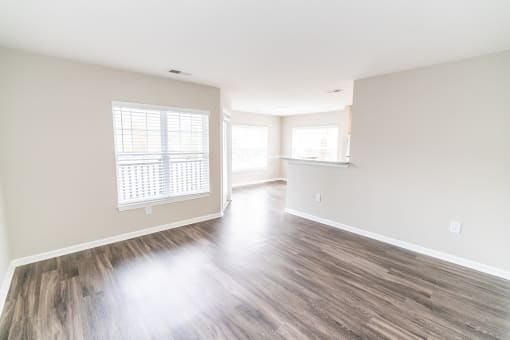 an empty living room with hardwood floors and a kitchen at Merion Milford Apartment Homes, Connecticut, 06460