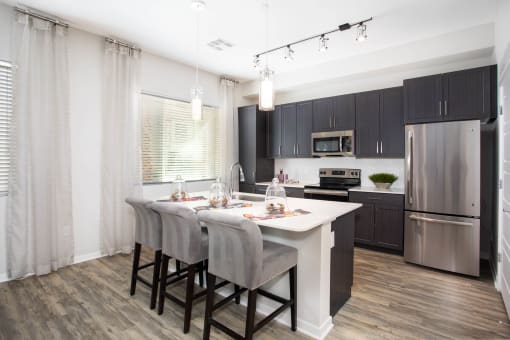 a kitchen with a white island and black cabinets