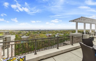 the view of the city from the balcony of a condo with chairs and a table