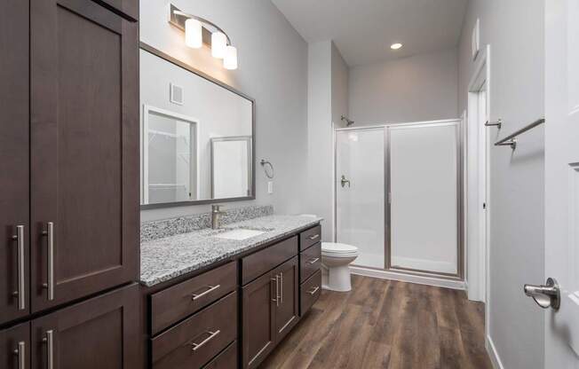 A bathroom with a wooden floor and white walls.