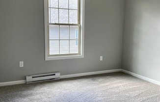 an empty room with a ceiling fan and a window