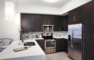 Waterfall edge quartz kitchen countertops and stainless steel appliances