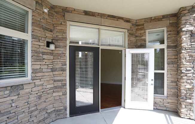 A stone wall with a black door and a white door.
