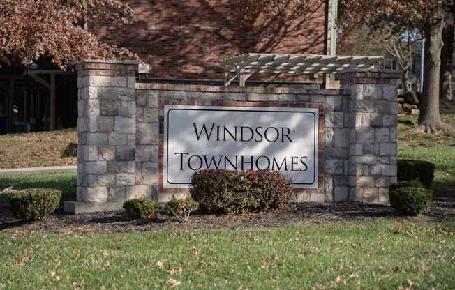 A sign that says Windsor Townhomes in front of a building.