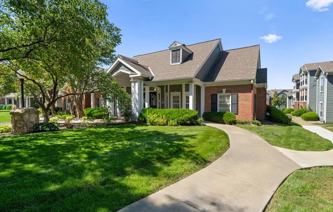 A house with a well-manicured lawn and a stone pathway leading to the front door. at Somerset Oaks Apartment Homes, Kansas