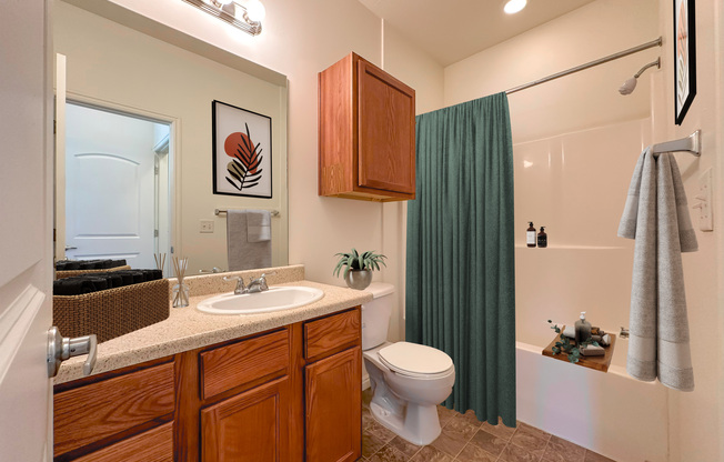 Liberty Commons Apartments, West Valley City, Utah, a bathroom with a sink, toilet, bathtub and shower and a green curtain