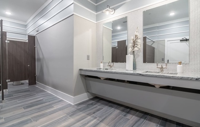 a large bathroom with a large mirror and a long counter with two sinks