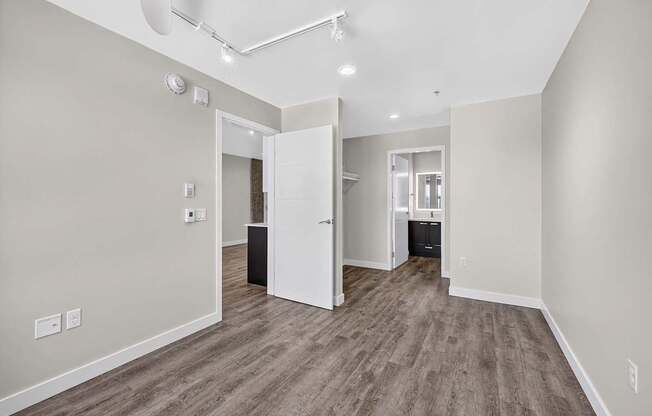 A room with a white door and a brown floor.