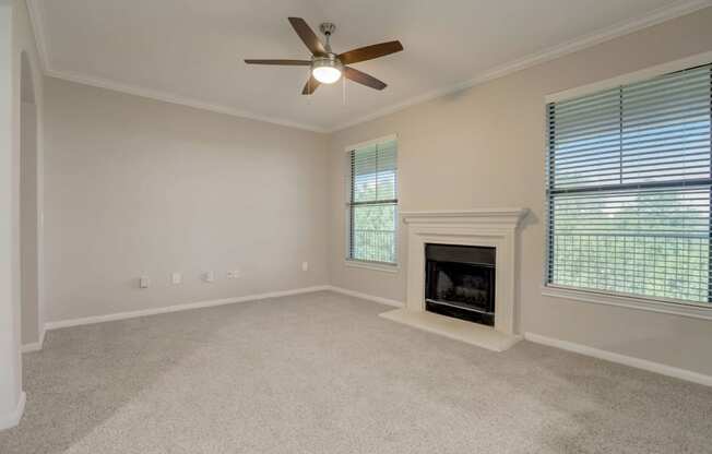 the living room has a fireplace and a ceiling fan at The Vista on Brodie, Austin, TX