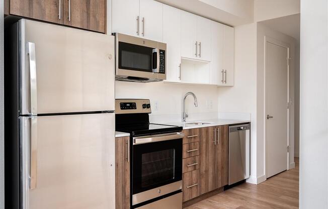 a kitchen with white cabinets and stainless steel appliances and a refrigerator