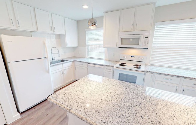 A kitchen with white cabinets and appliances.
