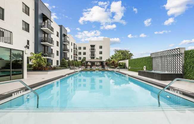a swimming pool with an apartment building in the background