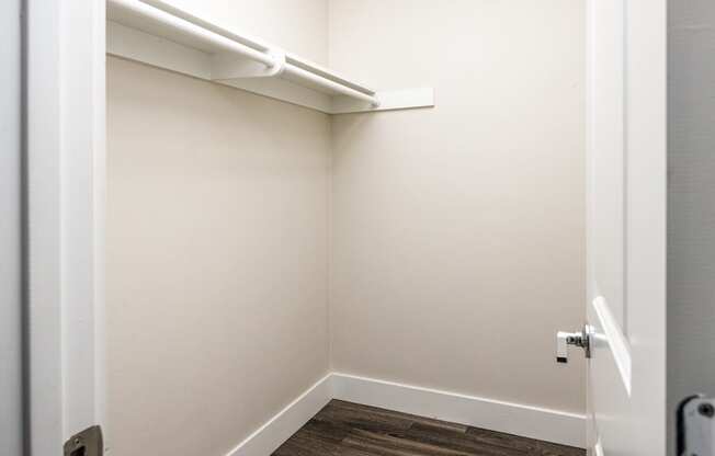 a small closet in a white room with a white door