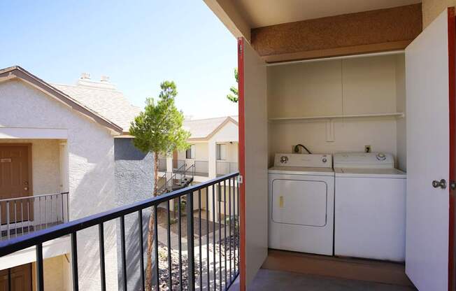 A balcony with a black railing and a white washer and dryer.