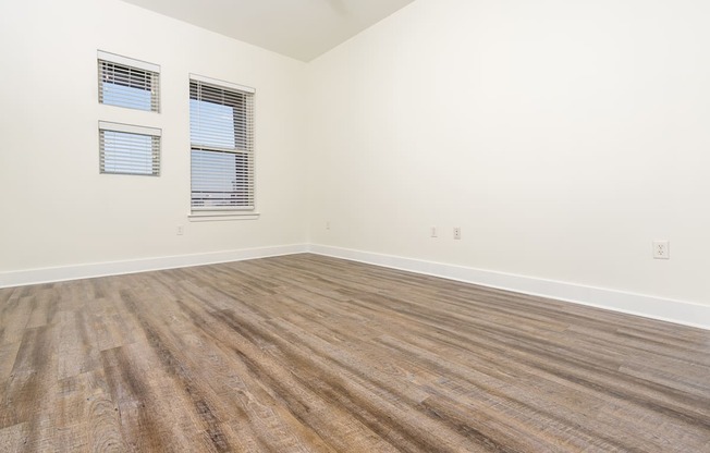 a bedroom with hardwood floors and white walls