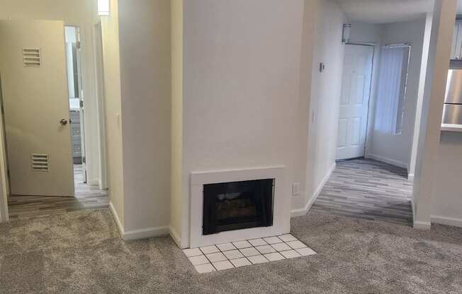A room with a fireplace and carpeting.