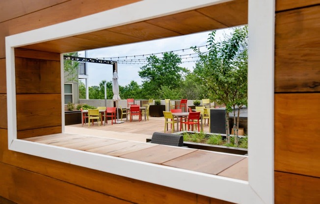 a window view of a patio with tables and chairs