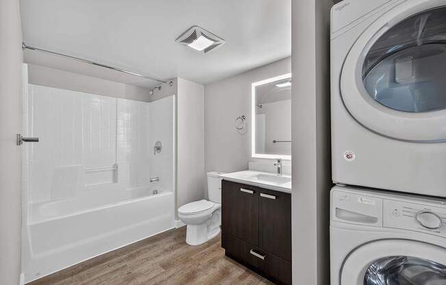 A white bathroom with a washer and dryer in it.