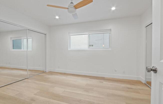 A room with a ceiling fan and a sliding glass door.