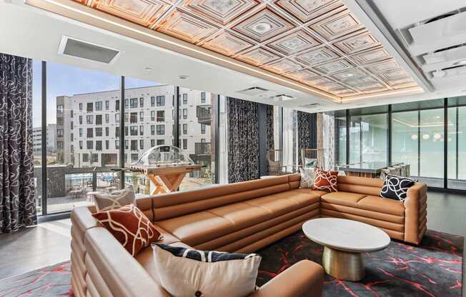 A living room with a large orange couch and a patterned rug.
