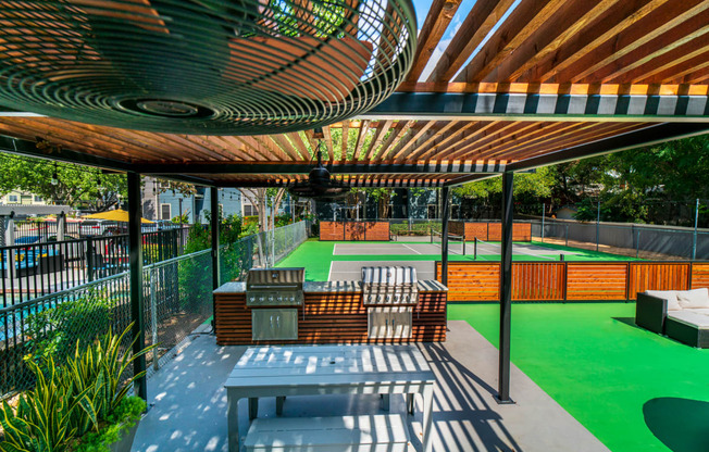 a patio with a table and chairs and a tennis court