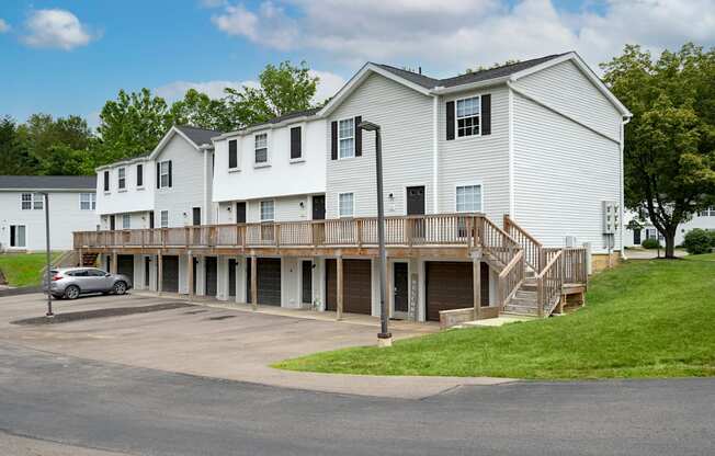 A white building with a car parked in front.