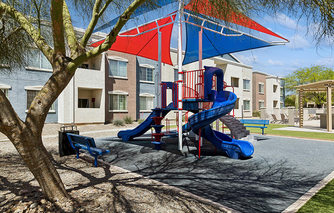 Community Playground with Slide and Blue/Red Canopy at Ridgeline Apartments in Tucson, AZ.