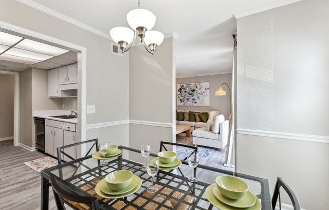 a dining room with a glass table and chairs