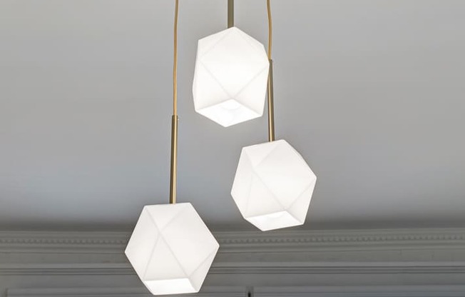 a trio of hanging lights in a room with a white ceiling