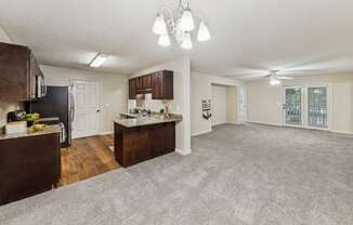 an open living room and kitchen with a carpeted floor  at Grand Reserve Columbus in Columbus, GA