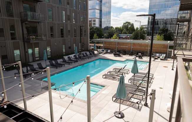 A rooftop pool with lounge chairs and umbrellas.