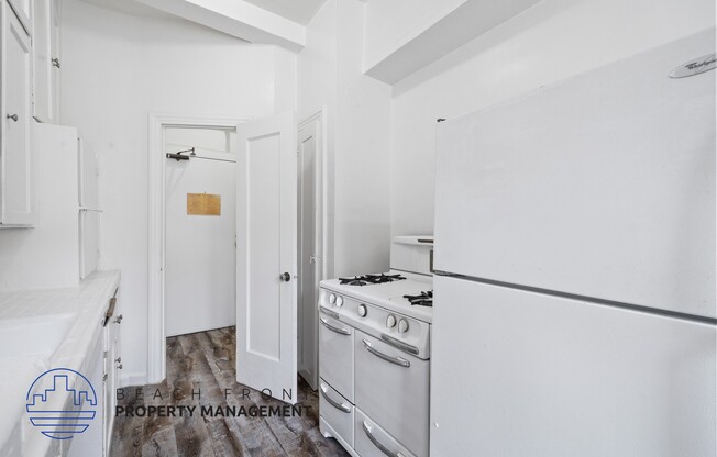 a white kitchen with white appliances and a white refrigerator