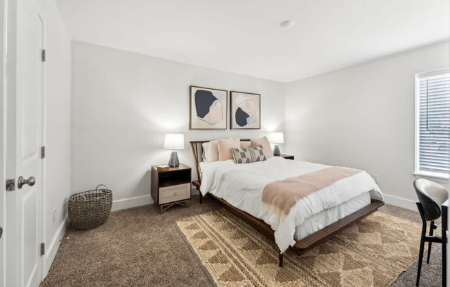 A bedroom with a bed, nightstands, and a rug.