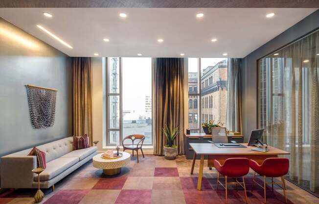 A modern living room with a white sofa, a coffee table, and a desk with a laptop.