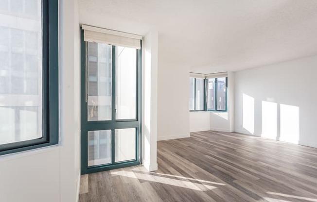 an empty room with white walls and wood floors